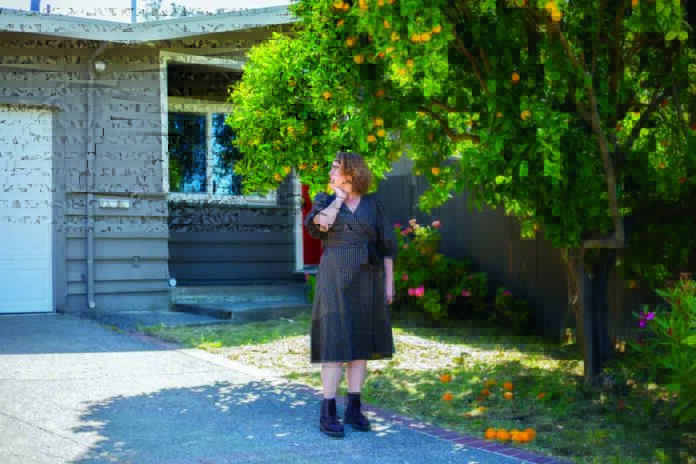 Photo by Nina Riggio for CalMatters UNINSURED Ashley Raveche stands in her front yard thinking about the future of fire for her neighborhood in Mill Valley on Friday, May 20.